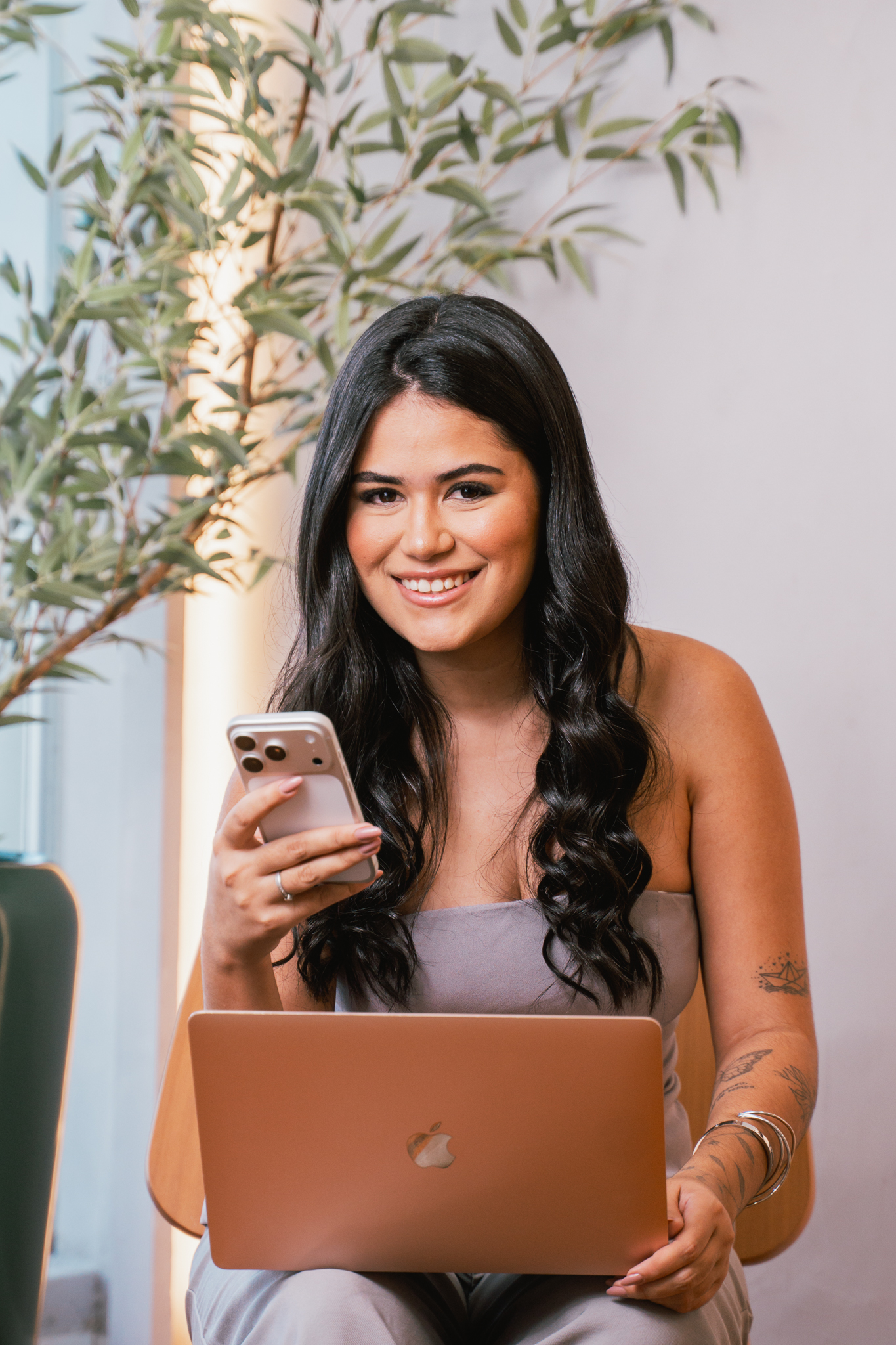 Milly Vieira com o celular e o notebook, pronta para planejar conteúdos
